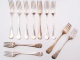 many forks and spoons laid out on the table