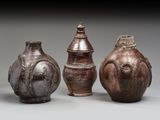 trois vases marron posés les uns à côté des autres sur une table
