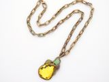a gold necklace with a yellow stone pendant on a chain