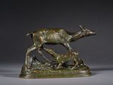 une statue en bronze représentant un cerf et deux biches dans un champ