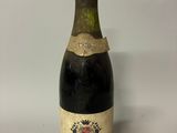 an old bottle of wine sitting on top of a white table