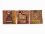 trois aimants en bois arborant des motifs différents, posés sur une surface blanche