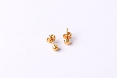 a pair of gold stud earrings on a white background