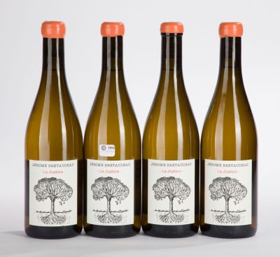 three bottles of wine are lined up on a white surface