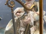 une statue représentant une femme tenant une harpe, exposée dans une vitrine