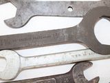 several wrenches are lined up on a white surface with a ruler