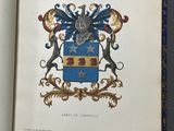 an open book with a picture of a coat of arms on it