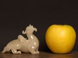 a small figurine of a horse and an apple on a table
