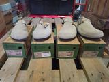 quatre paires de chaussures posées sur des cartons, sur une table