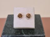 a close up of a pair of earrings sitting on top of a marble block