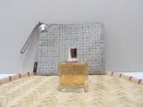 a bottle of perfume sitting on a table next to a purse