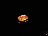 a close up of an orange diamond in the dark