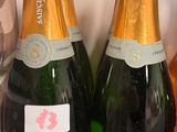 Trois bouteilles de champagne sont posées sur un comptoir, à côté d'une bouteille de vin