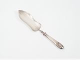 une cuillère en argent avec un manche en argent posée sur une surface blanche