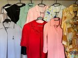 a lot of shirts hanging on a rack in a closet