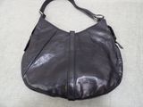 a close up of a black purse on a white surface