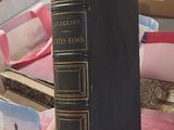 a person holding a book in their hand on a table