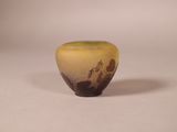 a small yellow vase sitting on a white surface