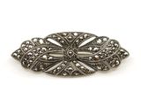 une broche ancienne en argent, ornée de filigranes sur fond blanc