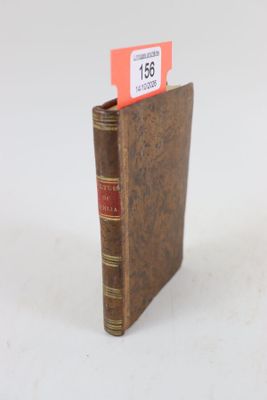un livre marron sur lequel est collée une étiquette rouge