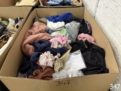 a cardboard box full of clothes sitting on the ground