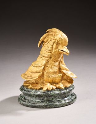 gold sculpture of a bird on a green marble base
