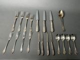 many forks and spoons laid out on a table
