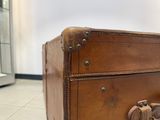 a brown suitcase sitting on the floor in a room