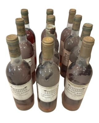 plusieurs bouteilles de vin sont alignées sur une surface blanche