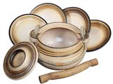 several pieces of pottery are arranged on a white surface with a wooden spoon