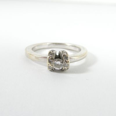 une image d'une bague en diamant sur une surface blanche