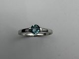 a close up of a ring with a blue stone in it