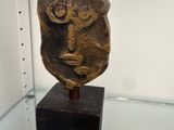 a stone sculpture of a face on display in a glass case