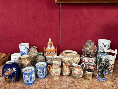 plusieurs vases posés sur une table, avec un mur rouge en arrière-plan
