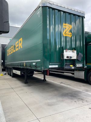 a green semi truck that is parked on the side of the road