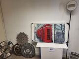 une photo d'une pièce avec une horloge, une horloge et une cabine téléphonique rouge
