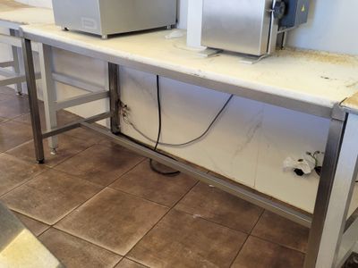 two microwaves sitting on a table in a kitchen
