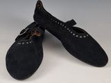 paire de chaussures en daim noir avec des boucles métalliques sur le bout