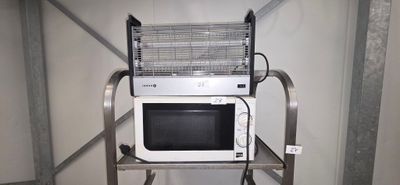a microwave sitting on top of a metal shelf