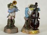 trois figurines représentant une grenouille jouant d'un instrument de musique