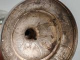 someone is holding a silver plate with a flower design on it