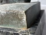 a statue of a man sitting on top of a marble block