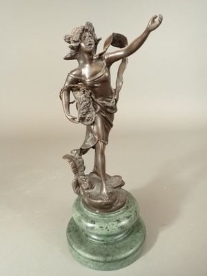 statue d'une femme tenant un panier de fleurs, posée sur un socle en marbre