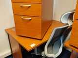un bureau à tiroirs et une chaise dans un coin