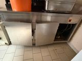 une cuisine équipée d'un évier en inox et d'un lave-vaisselle