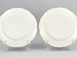 pair of white plates on stand on grey background
