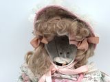 a teddy bear that is wearing a dress and a bonnet