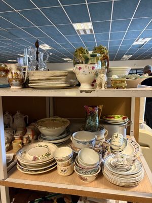 de nombreuses assiettes et bols sur une étagère dans un magasin