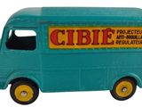 un petit camion jouet bleu avec des roues jaunes et une pancarte sur le côté