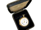 une petite boîte noire contenant une horloge dorée